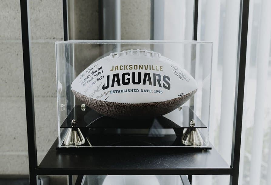 A signed football in a display case, inscribed: Dr. Koh, thanks for all of your help