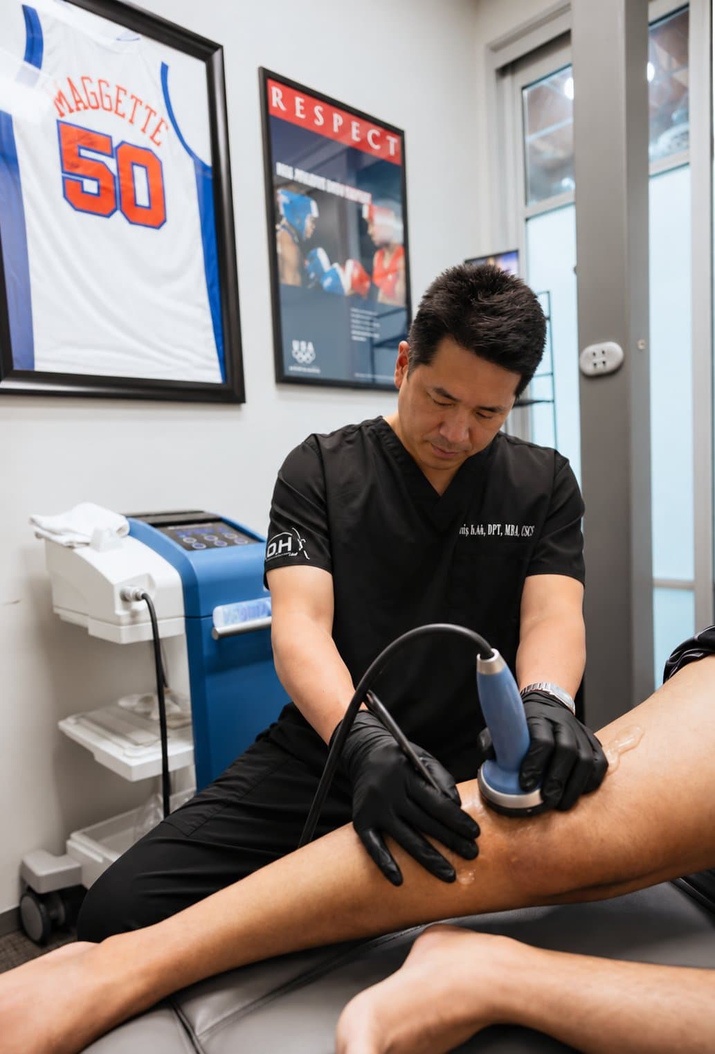 Davis Koh, DPT, treating a patient's leg in a KOH Physical Therapy Lab treatment room