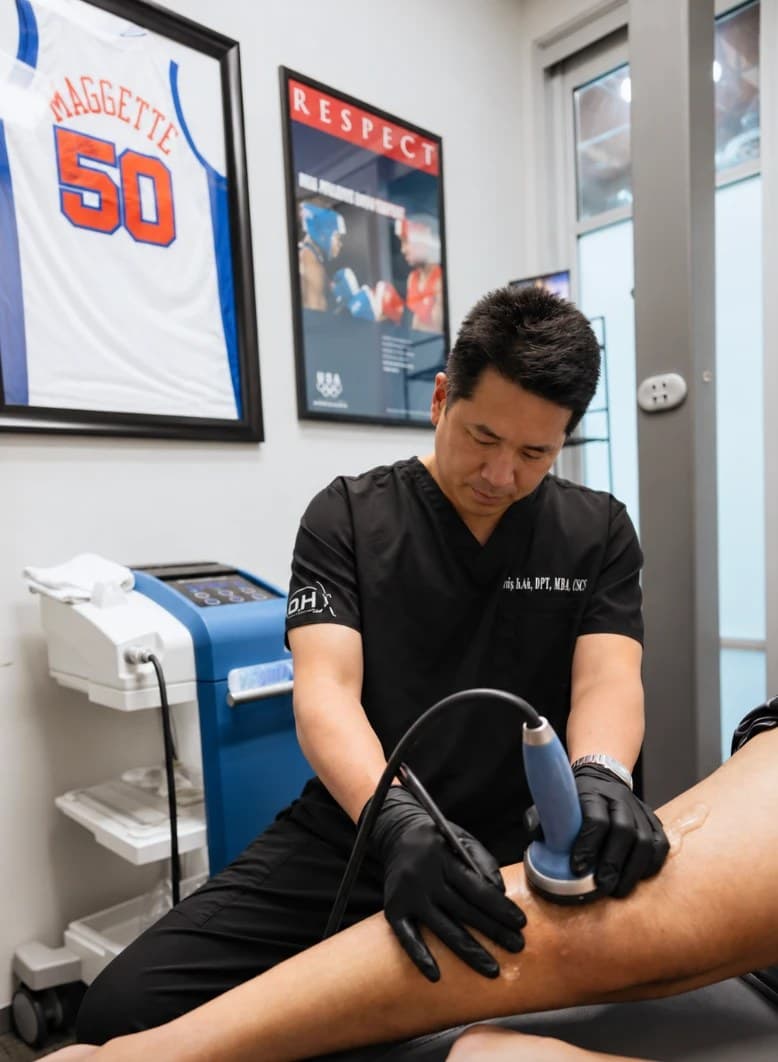 Davis Koh, DPT, working with a client on a treatment table in a private treatment room