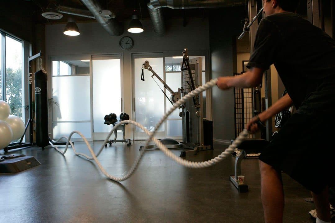 A person gripping the ends of heavy battling ropes in the KOH Physical Therapy Lab gym