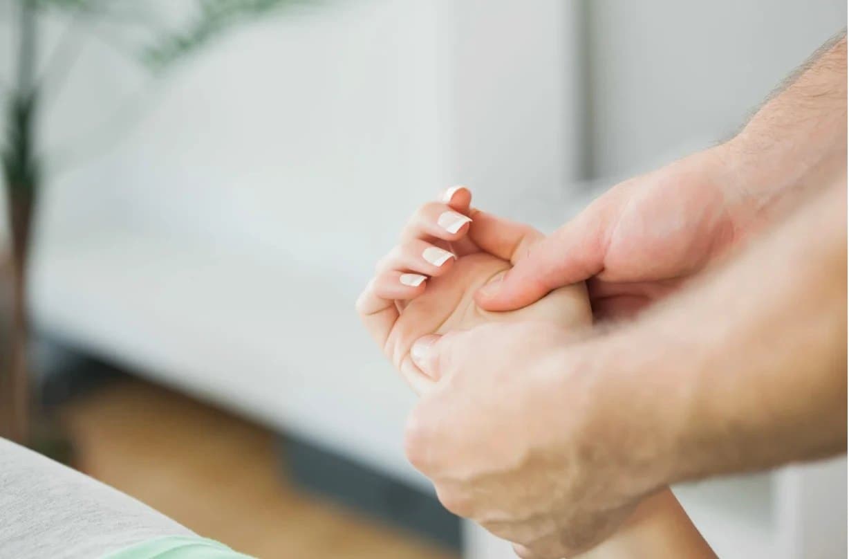 A clinician's hands treating a client's hand