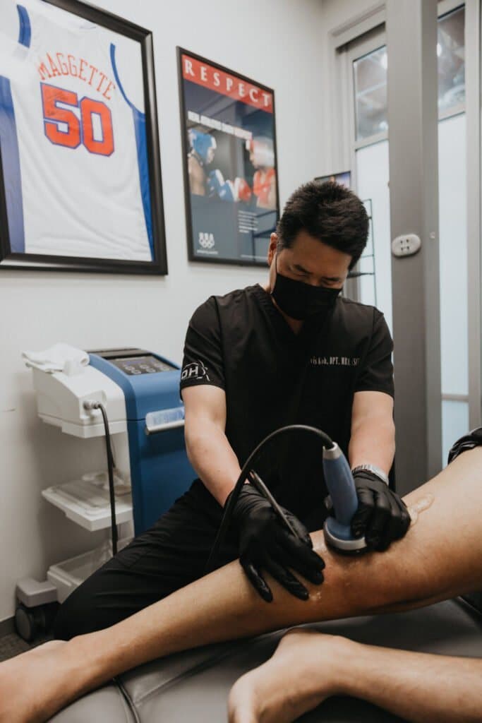 Davis Koh, DPT, treating a client's leg in a KOH Physical Therapy Lab treatment room